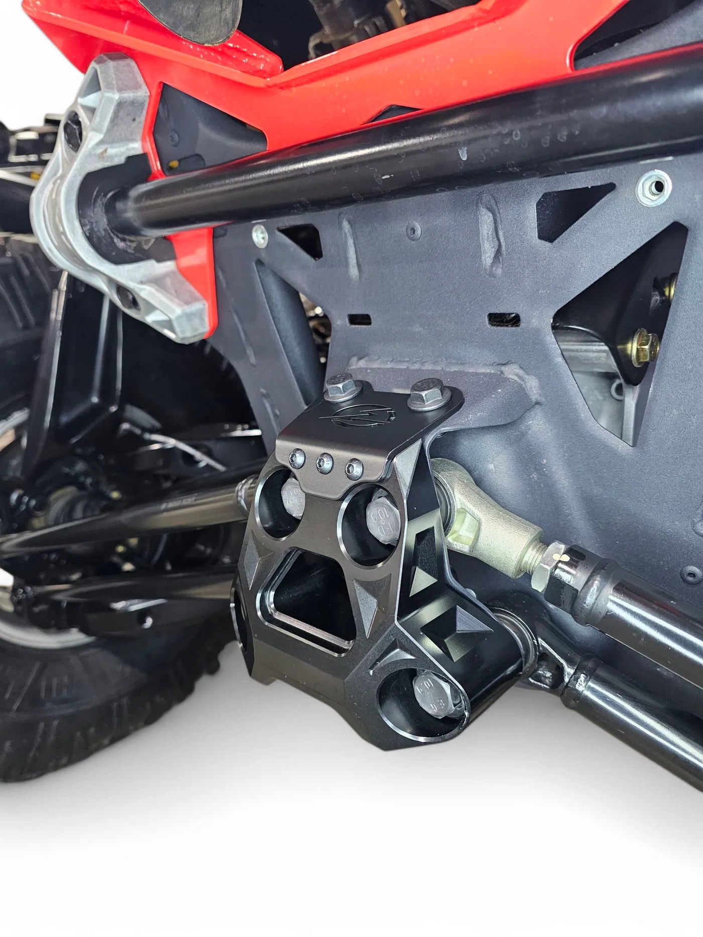 Close-up of a utv radius rod plate and suspension system on a white background