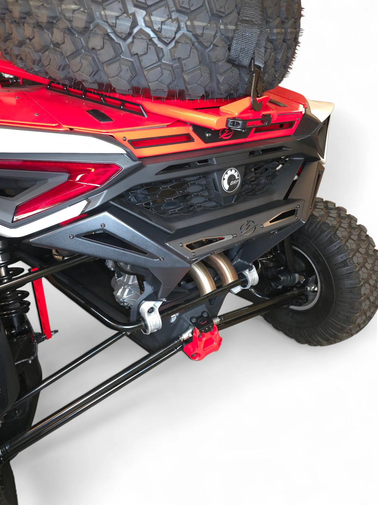Close-up of a red and black off-road vehicle with a spare tire on a white background