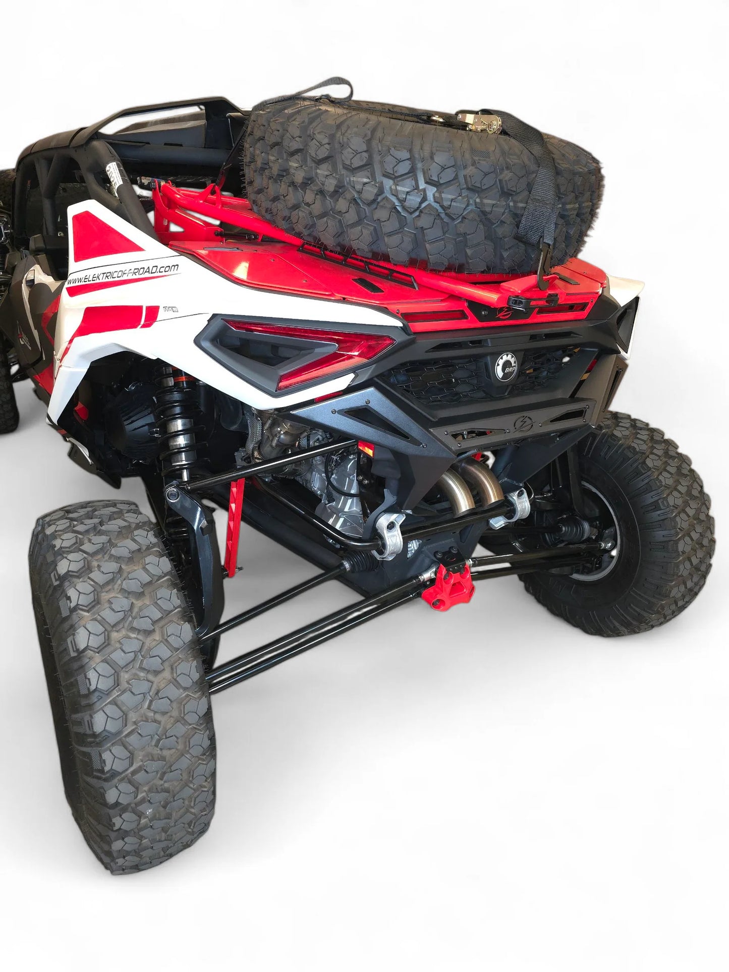 Red and black off-road vehicle with large tires on a white background