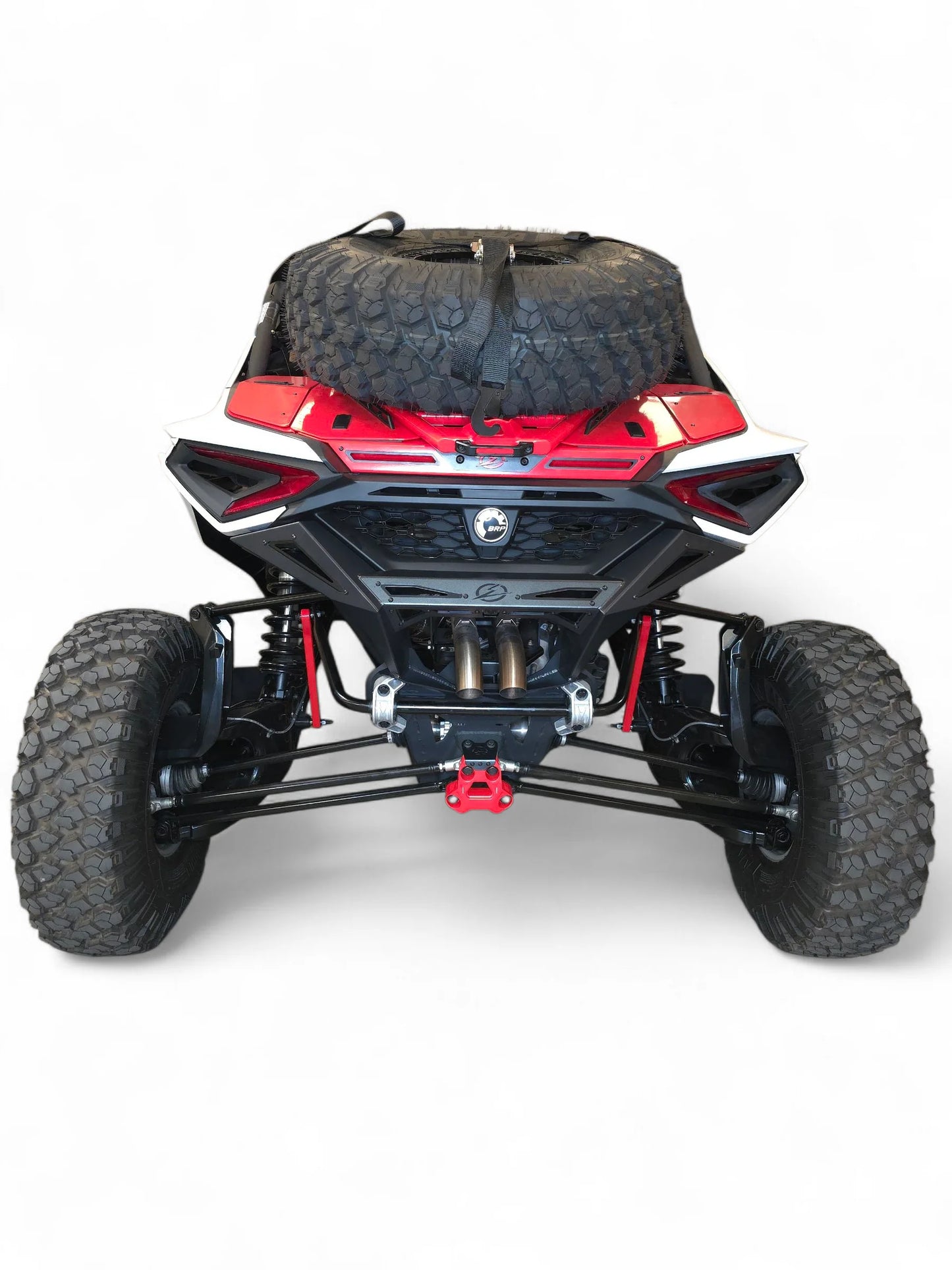 Back view of a red and black off-road vehicle with large tires on a white background