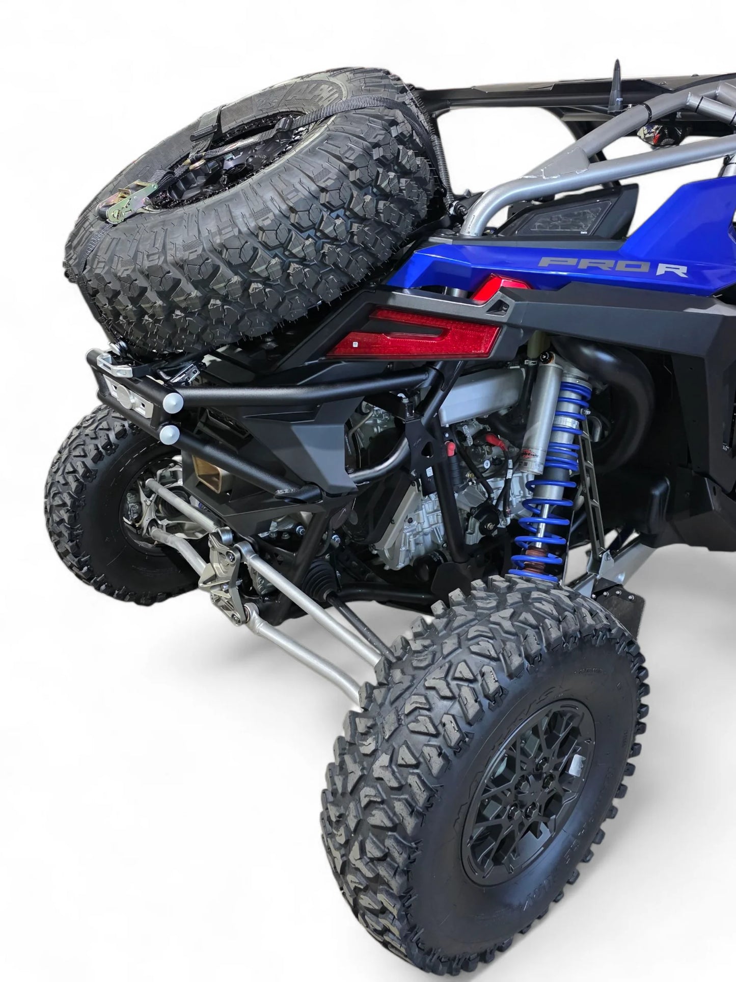 Side view of a blue and black off-road vehicle with large tires on a white background
