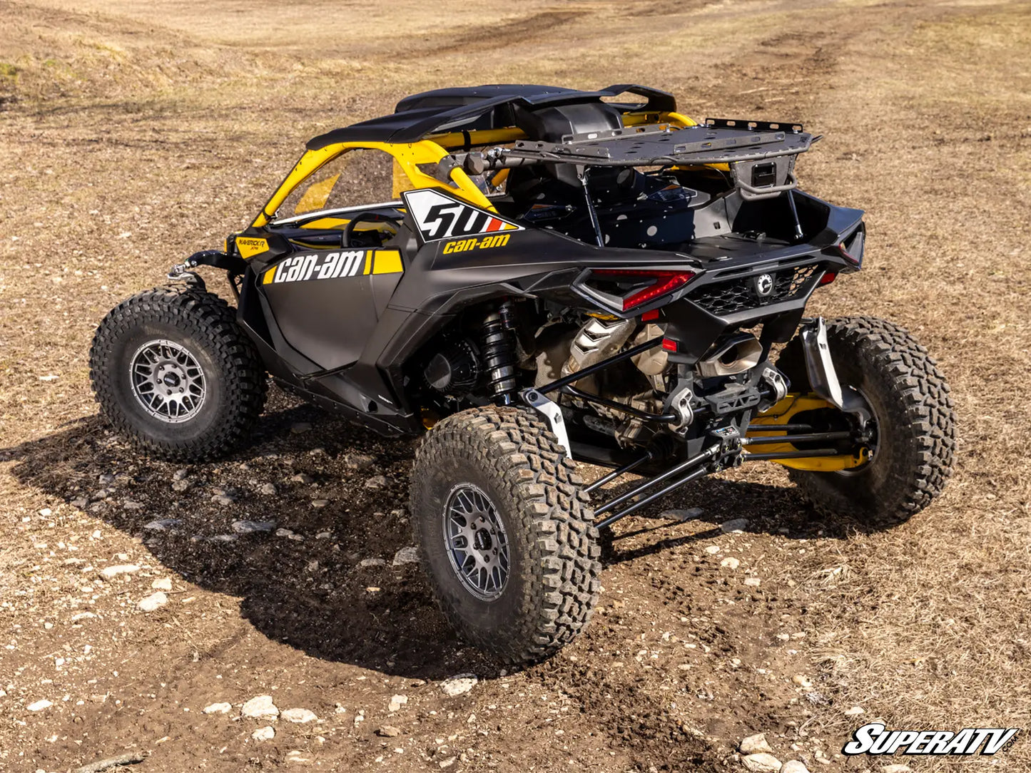 Can-Am off-road vehicle on a dirt surface with 'SuperATV' branding.