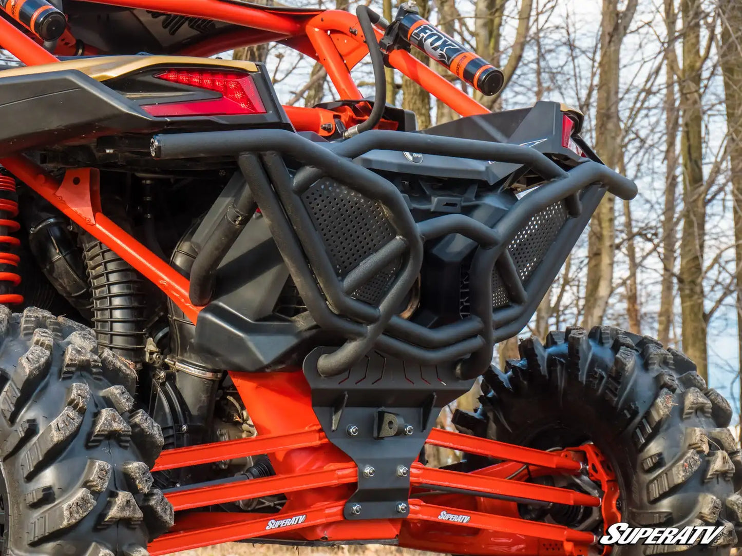 Close-up of a red and black off-road vehicle with a forest background