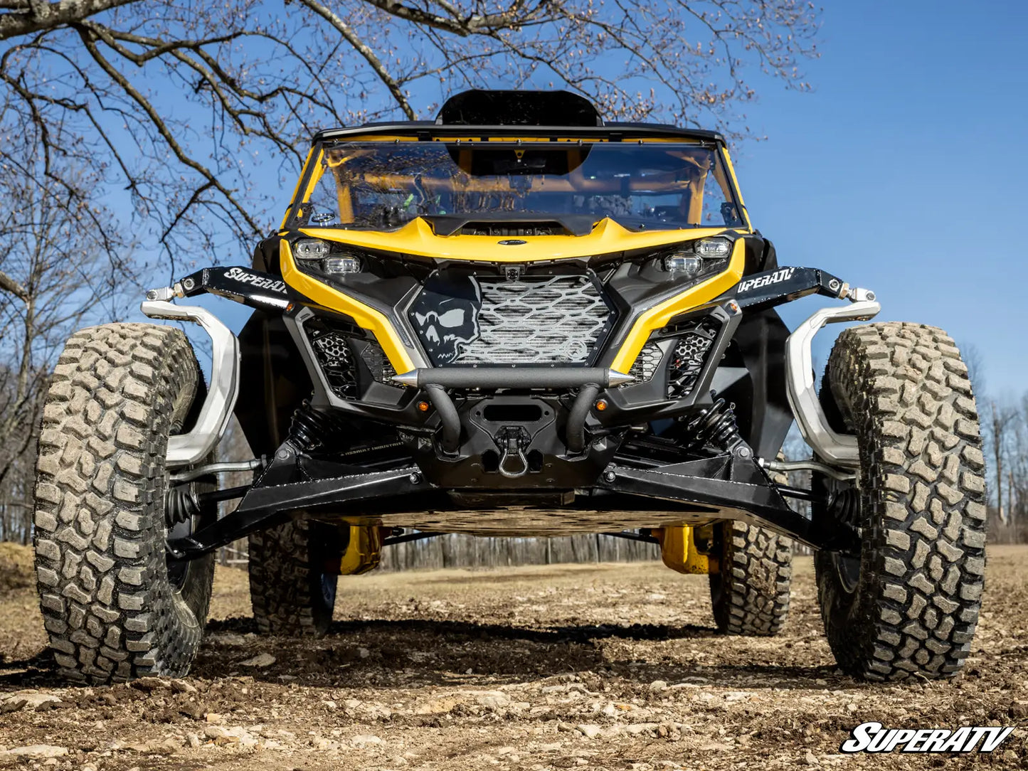 Yellow and black off-road vehicle on a dirt path with clear blue sky