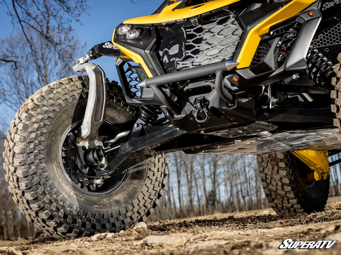 Yellow and black ATV on a dirt path with trees in the background