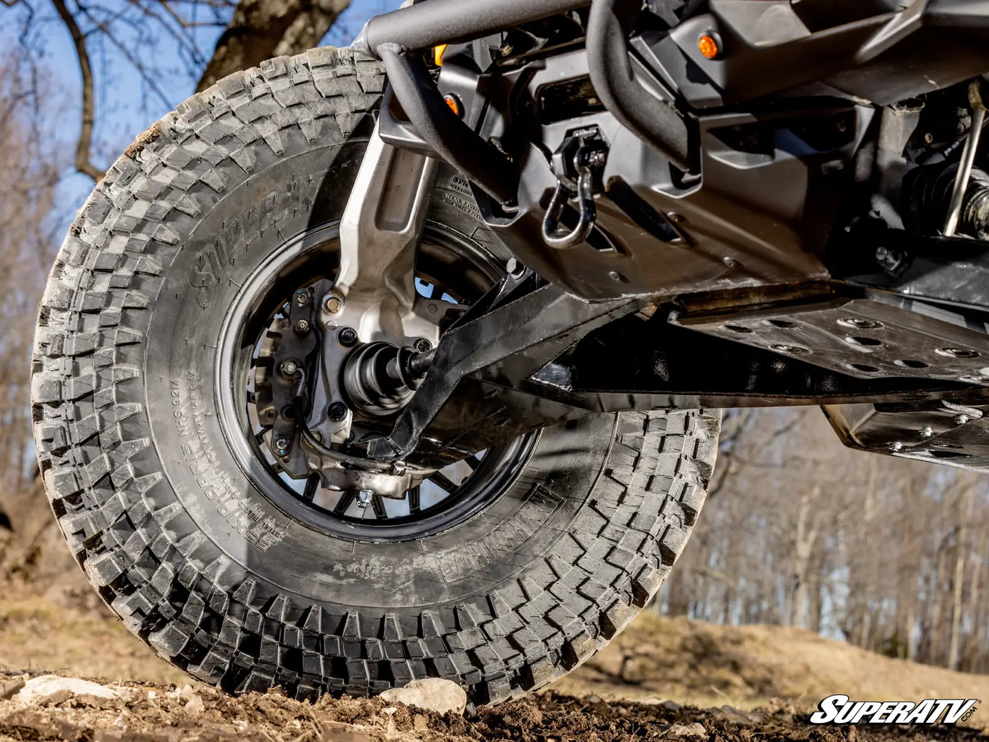 Close-up of a rugged tire on an ATV with a blurred natural background