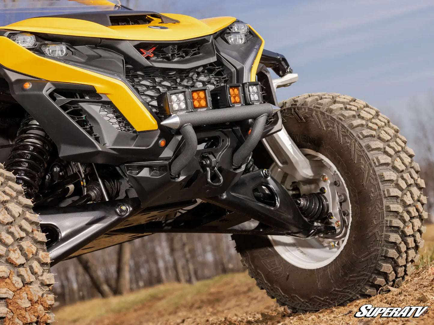 Close-up of a yellow and black ATV with 'SuperATV' branding on a natural background.