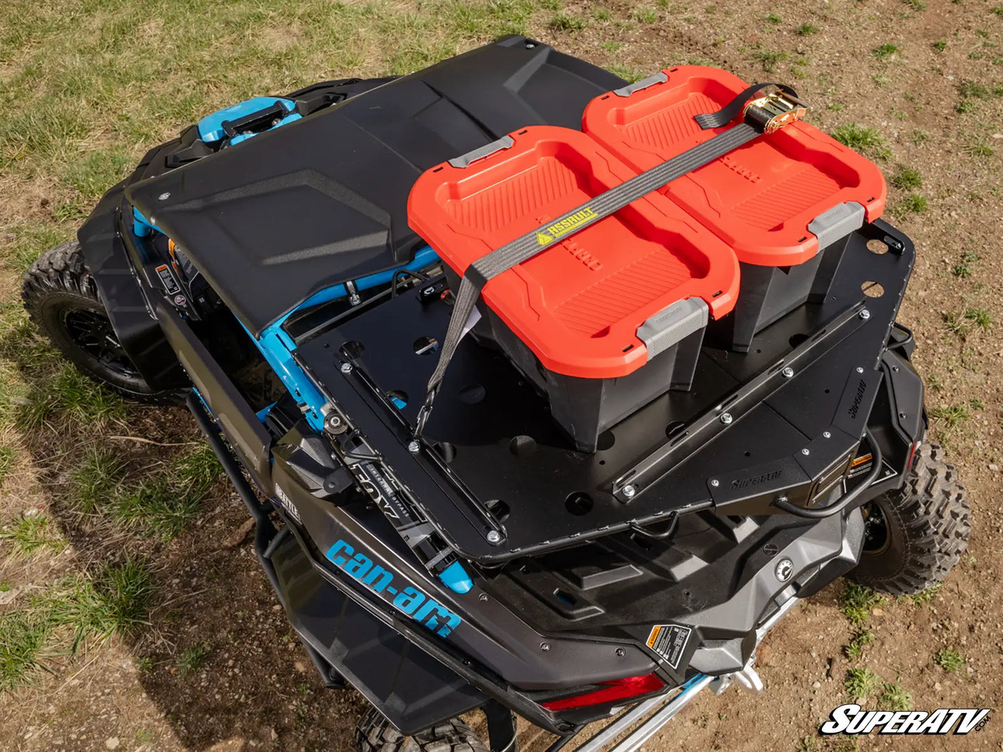 Black UTV with orange storage bins on a grassy field