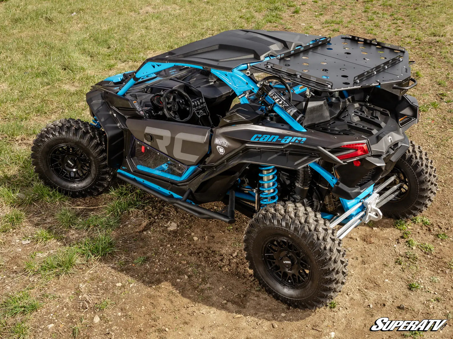 Off-road vehicle with 'SuperATV' branding on a grassy and dirt surface.