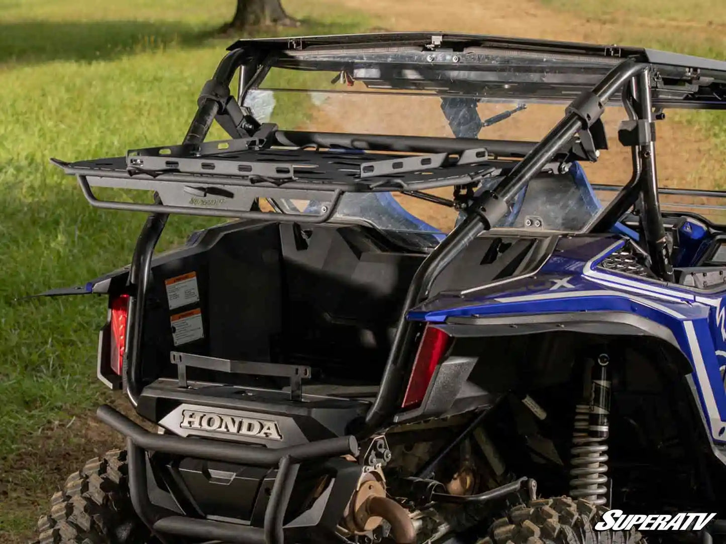 Honda UTV with SuperATV rack in a grassy outdoor setting