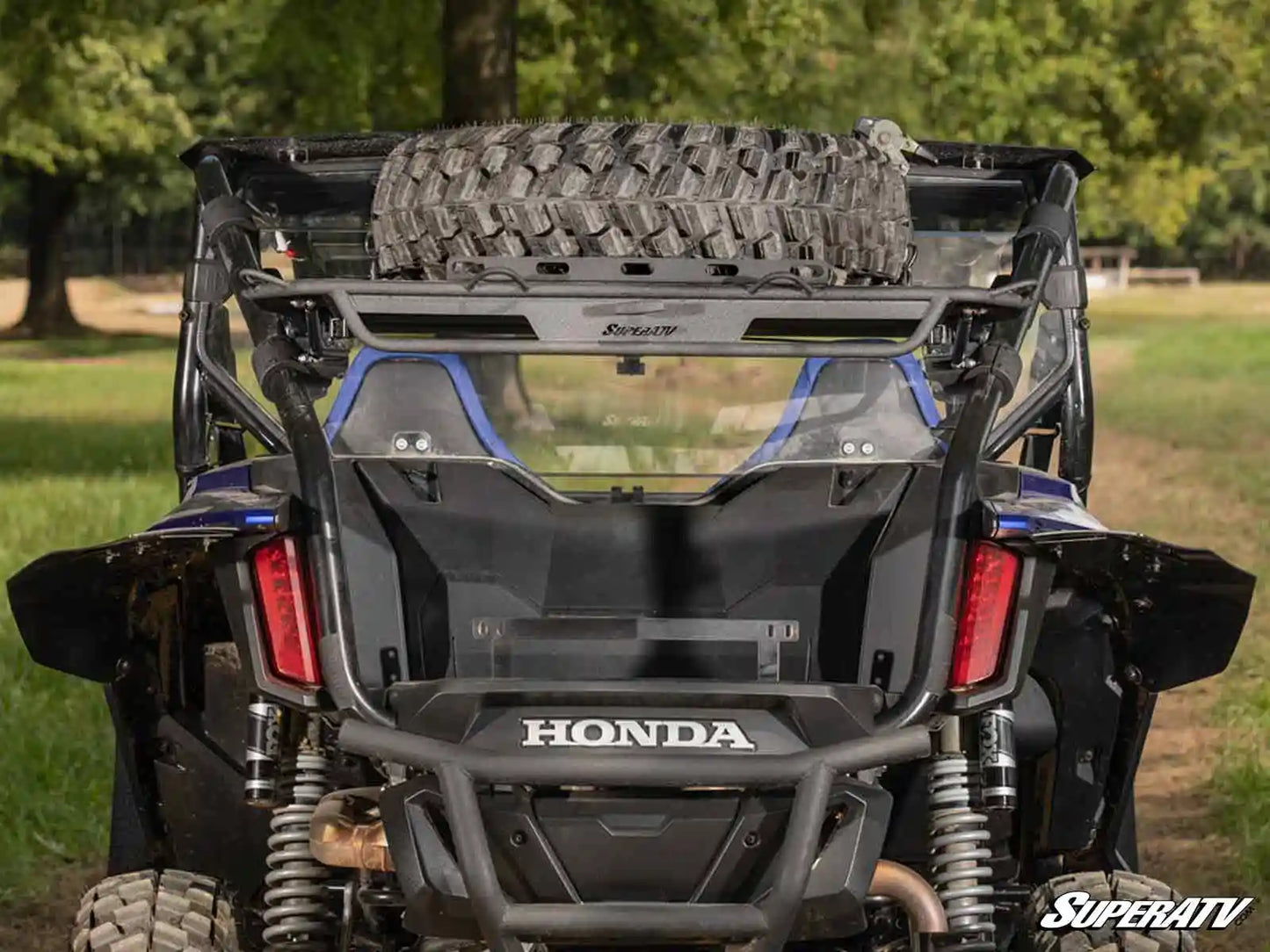 Honda SuperATV vehicle with tire on a grassy field