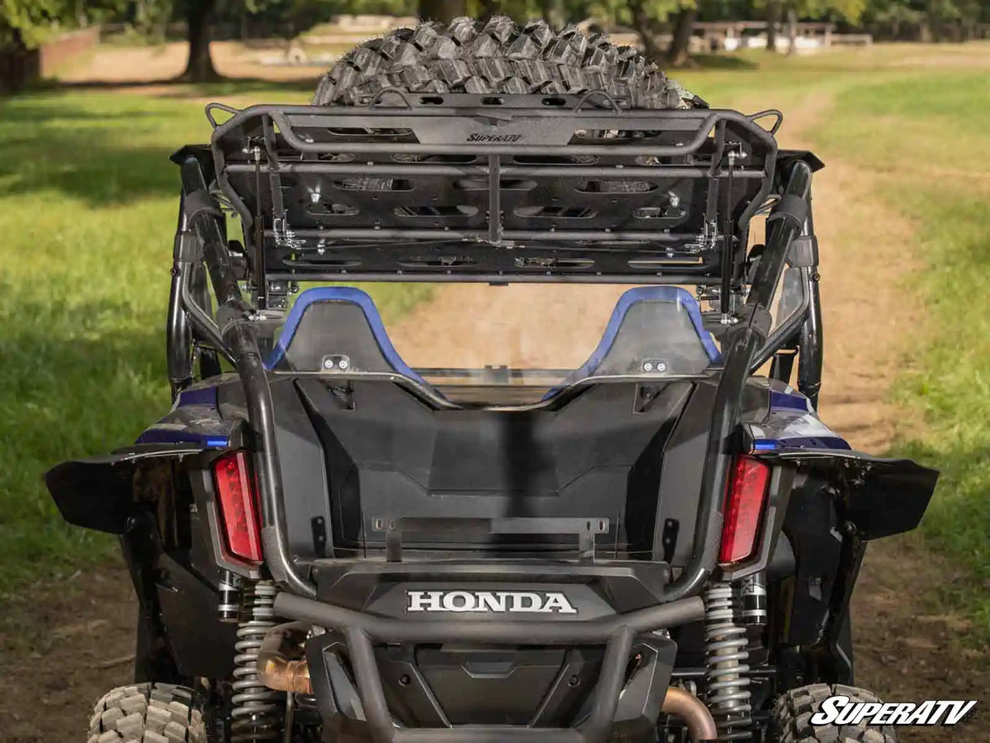 Honda ATV with SuperATV equipment in a grassy field