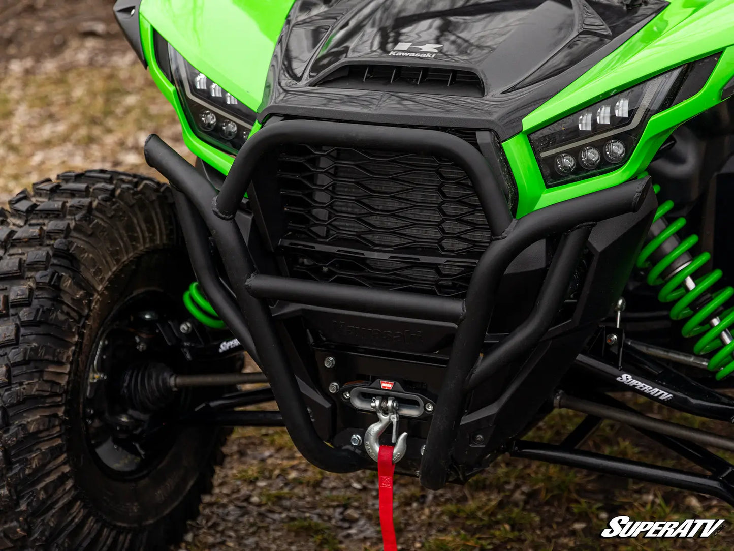 Close-up of a green ATV with a SuperATV logo on a natural outdoor background