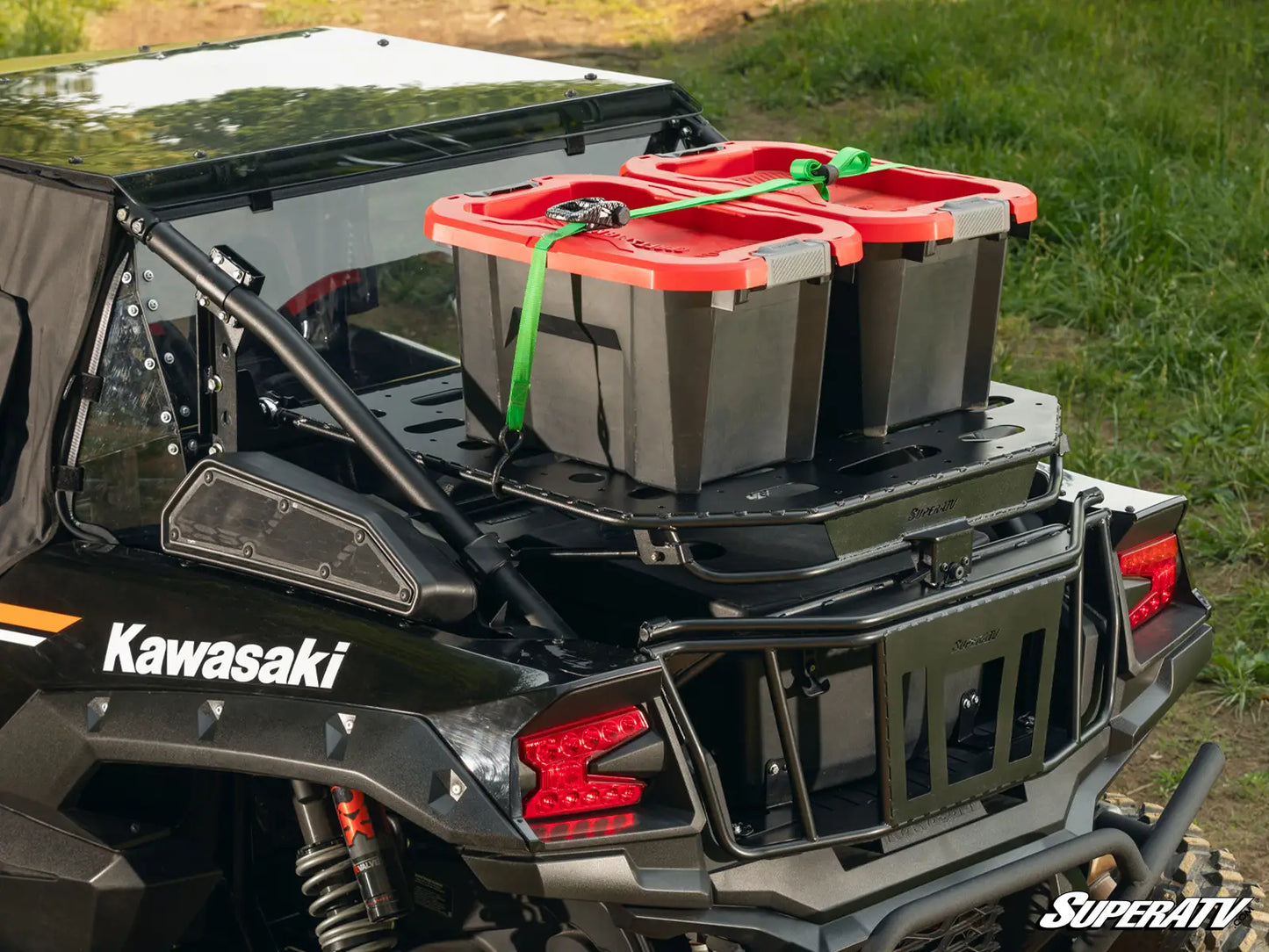 Kawasaki vehicle with storage bins on a grassy background