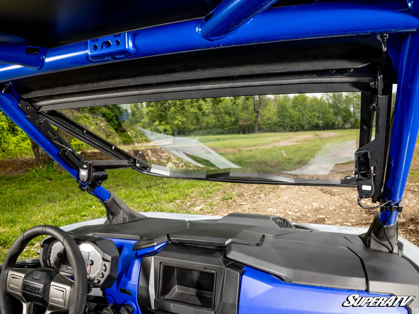 Close-up of a blue off-road vehicle with a clear windshield and visible interior.