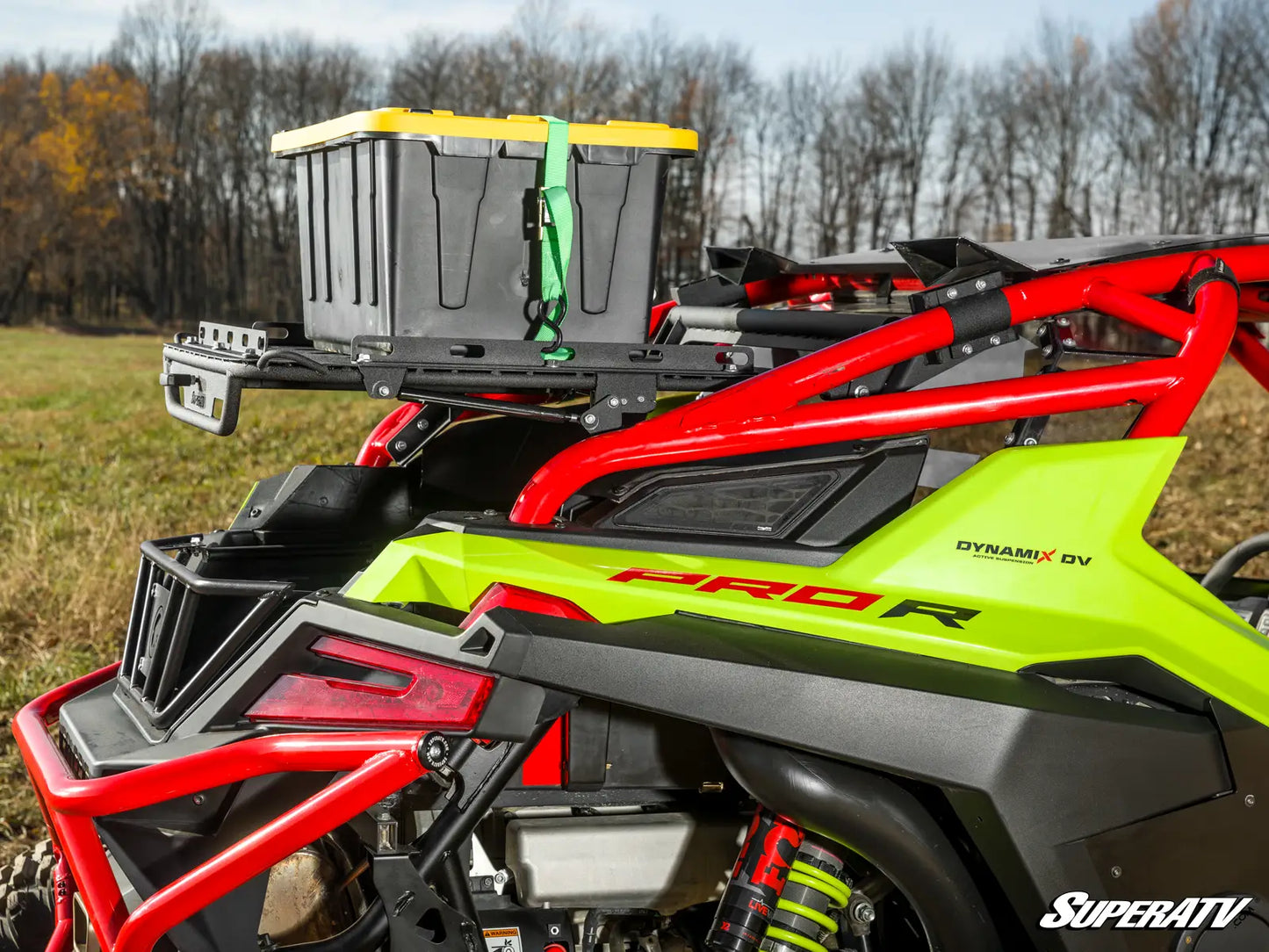 Green and red ATV with storage box on a grassy field