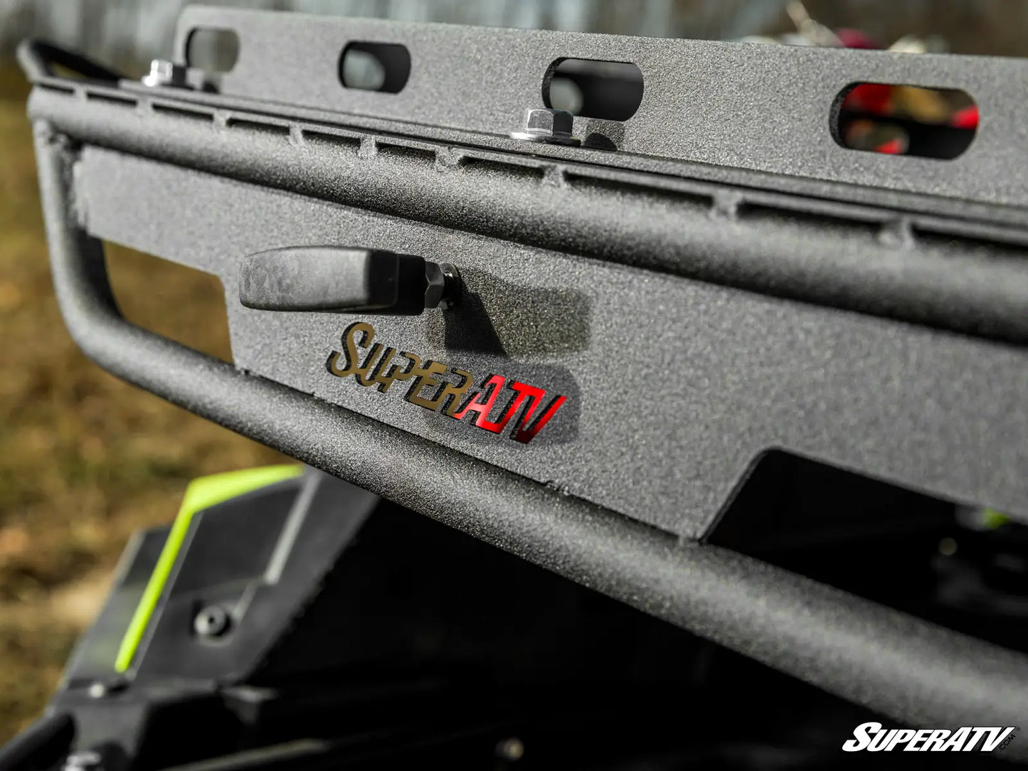 Close-up of a SuperATV bumper on an off-road vehicle with blurred background