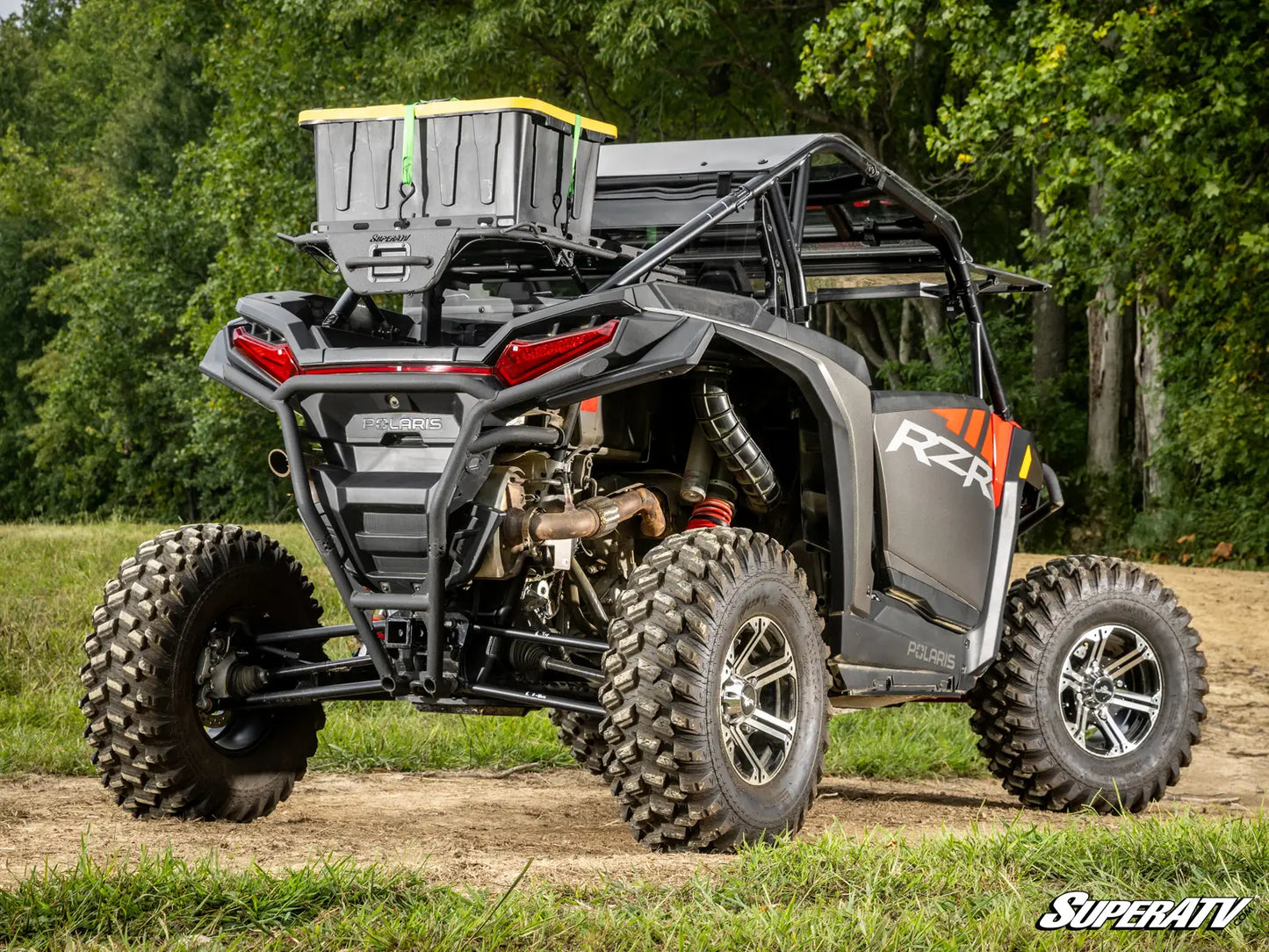 SuperATV off-road vehicle on a dirt path with trees in the background