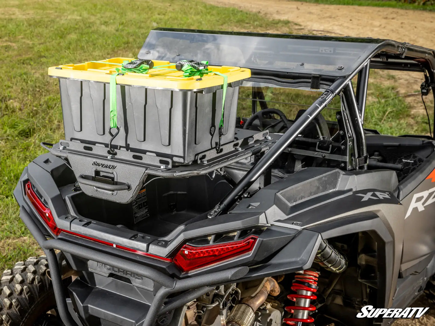 Close-up of a SuperATV storage box on an off-road vehicle with grass in the background