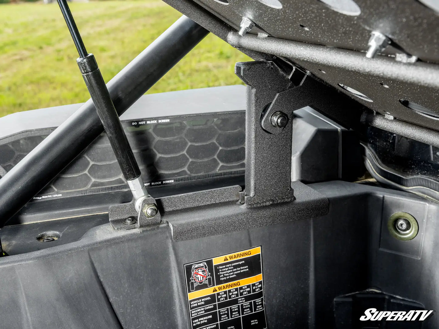 Close-up of a SuperATV product with a warning label on a vehicle's roof rack.