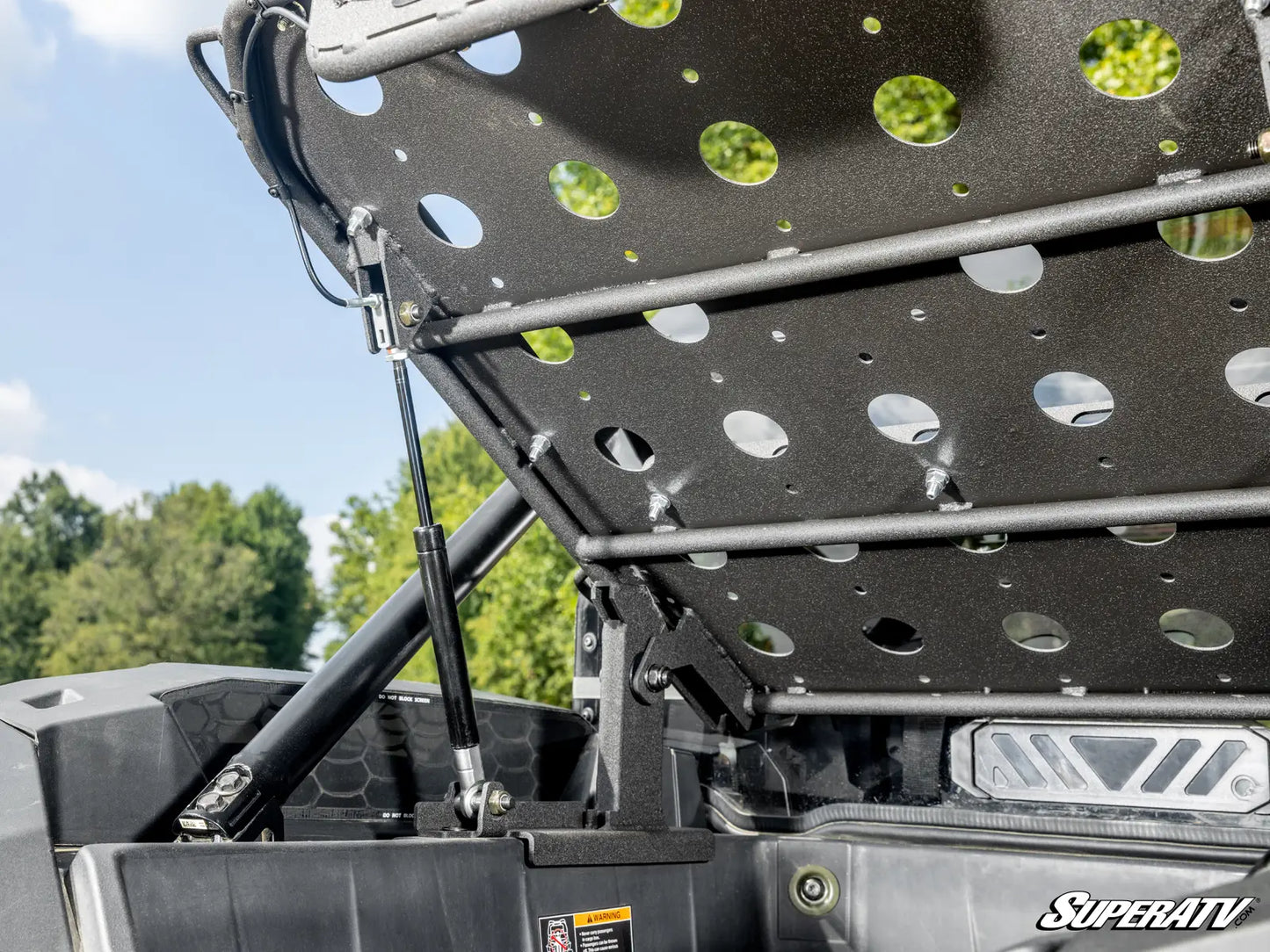 Close-up of a black metal rack with green bolts on a SuperATV product.