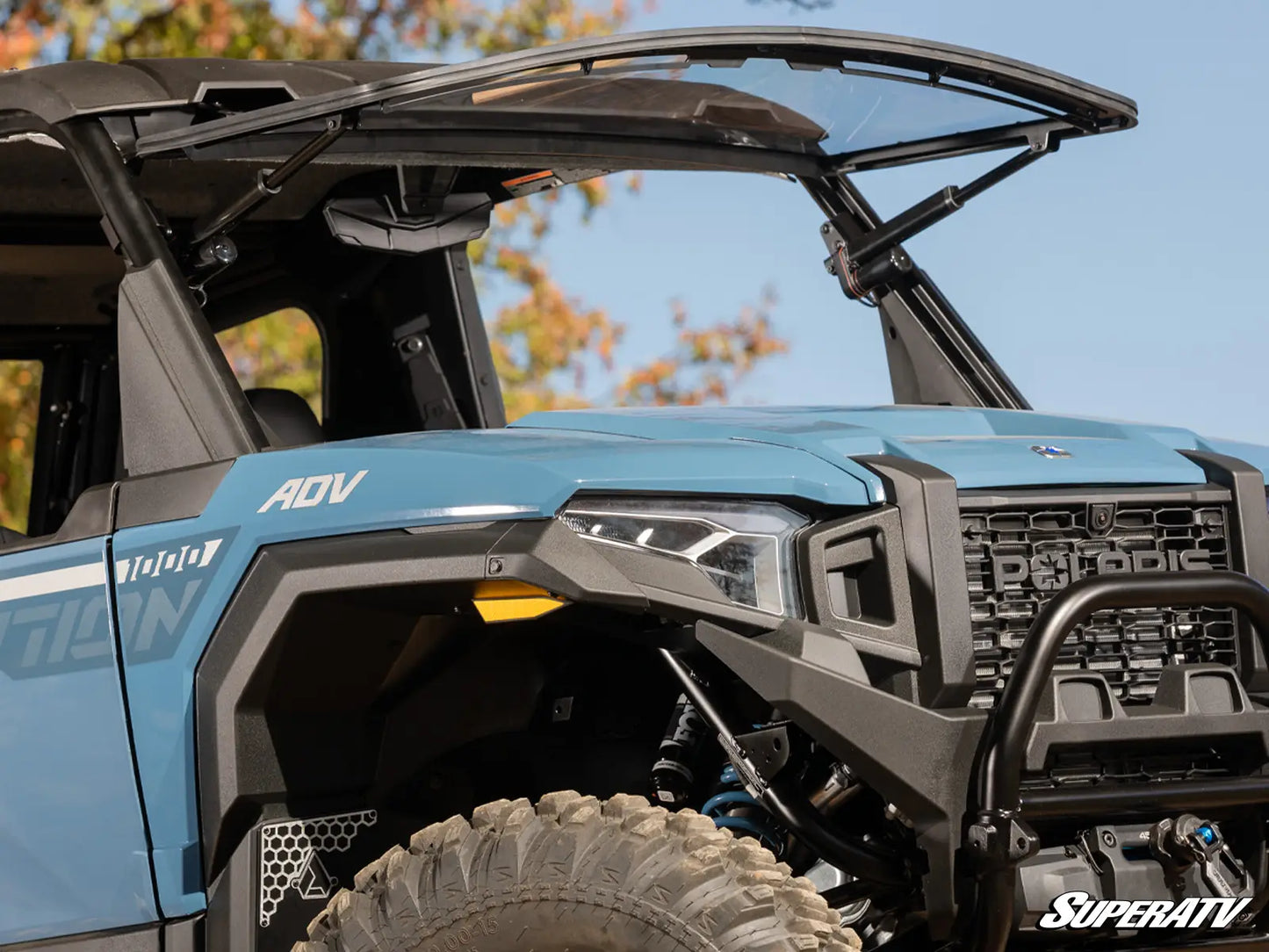 Close-up of a blue SuperATV vehicle with open doors and clear windshield.