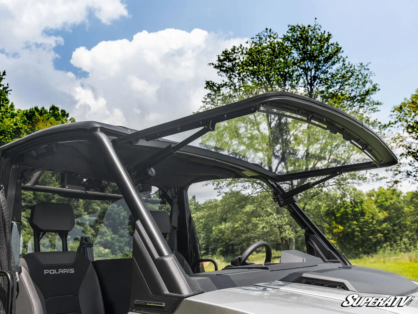 Side view of a Polaris vehicle with an open door in a forest setting