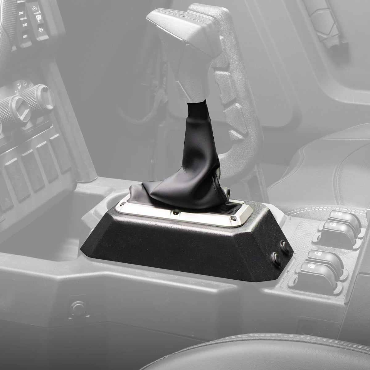 A black leather gear shift boot installed on a manual transmission shifter console inside a vehicle cabin.