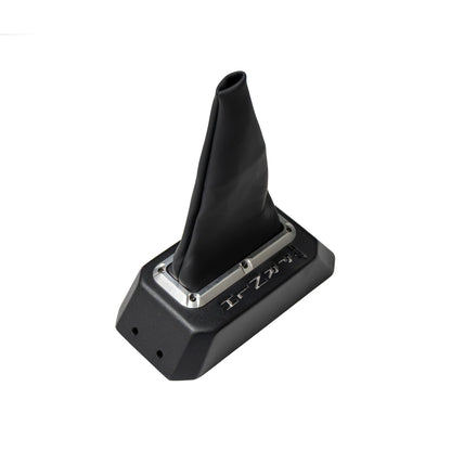 A black manual gear shift boot and base assembly with a silver metal accent ring, shown on a plain white background.