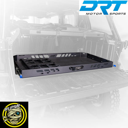 A black DRT Motor Sports under-bed storage tray mounted in the bed of a vehicle, shown against a faded white vehicle background with DRT Motor Sports branding in the top right and a BFE Offroad logo in the bottom left.