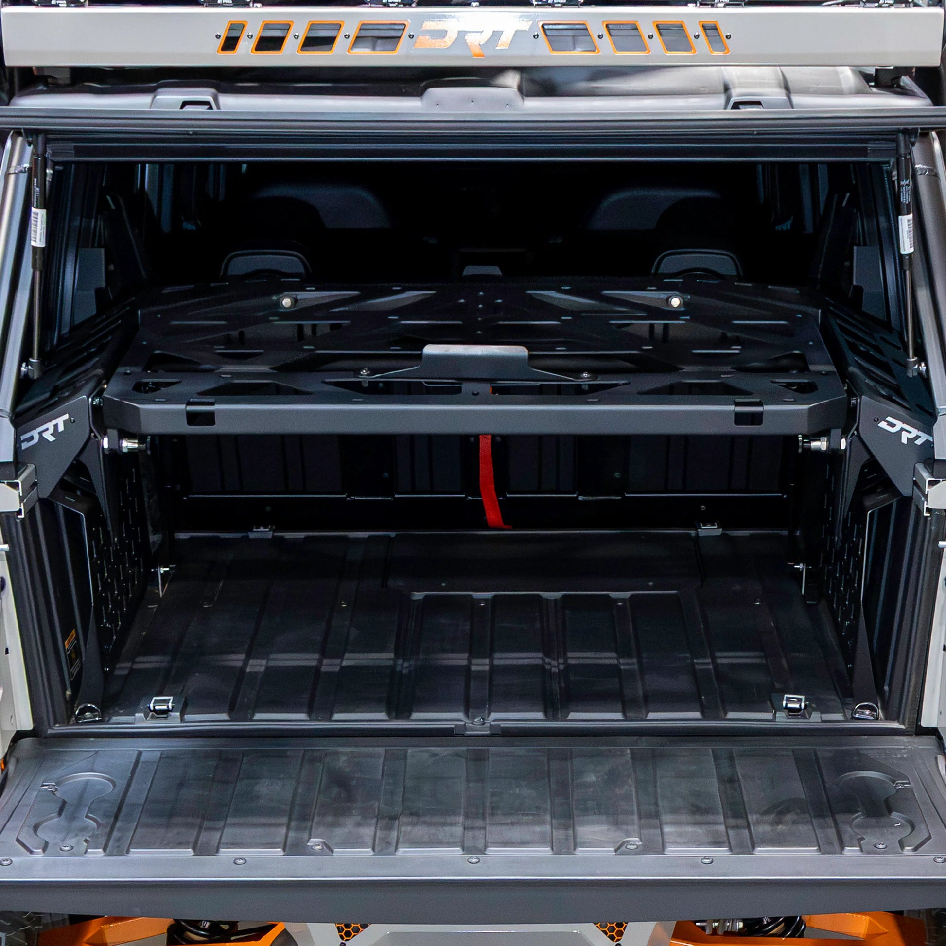 Open cargo area of a vehicle with a black storage tray