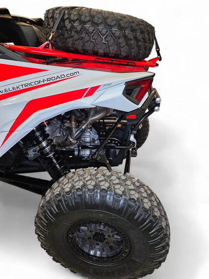 Close-up of a red and white off-road vehicle with large black tires on a white background.