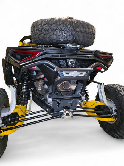 Close-up of a yellow and black off-road vehicle chassis with a spare tire on a white background