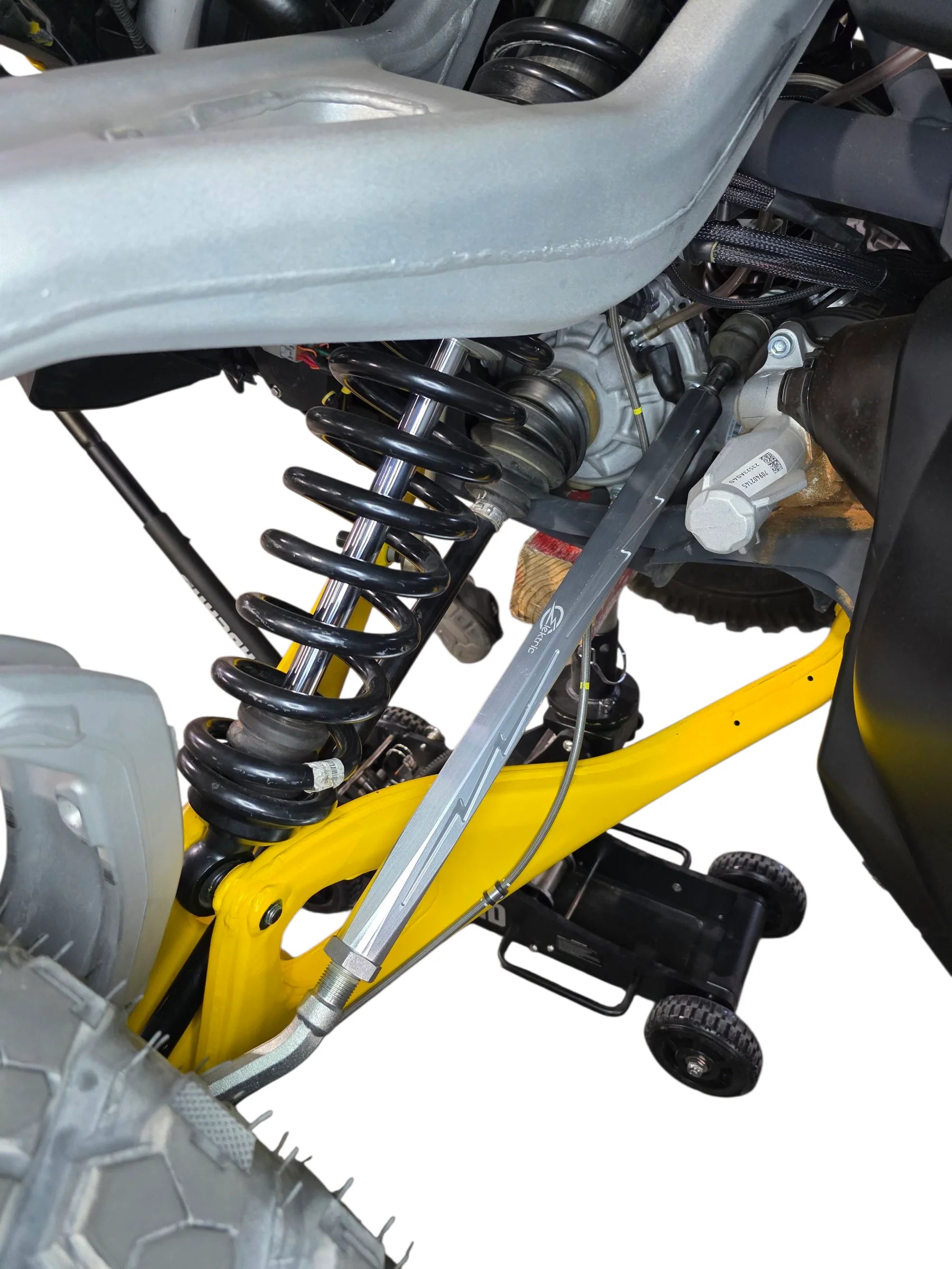 Close-up of a motorcycle suspension system with a yellow jack stand.