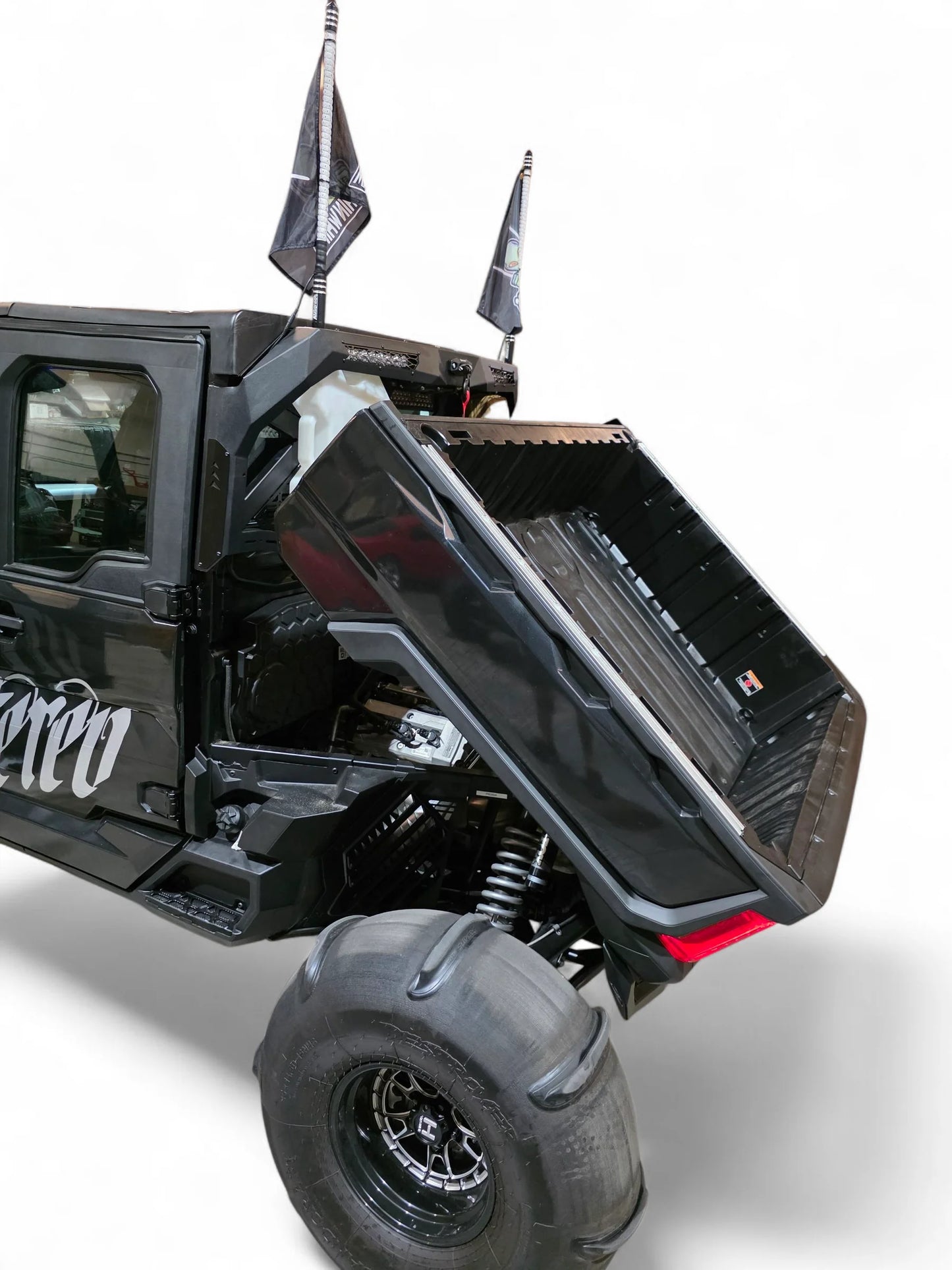 Black off-road vehicle with open cargo bed on a white background