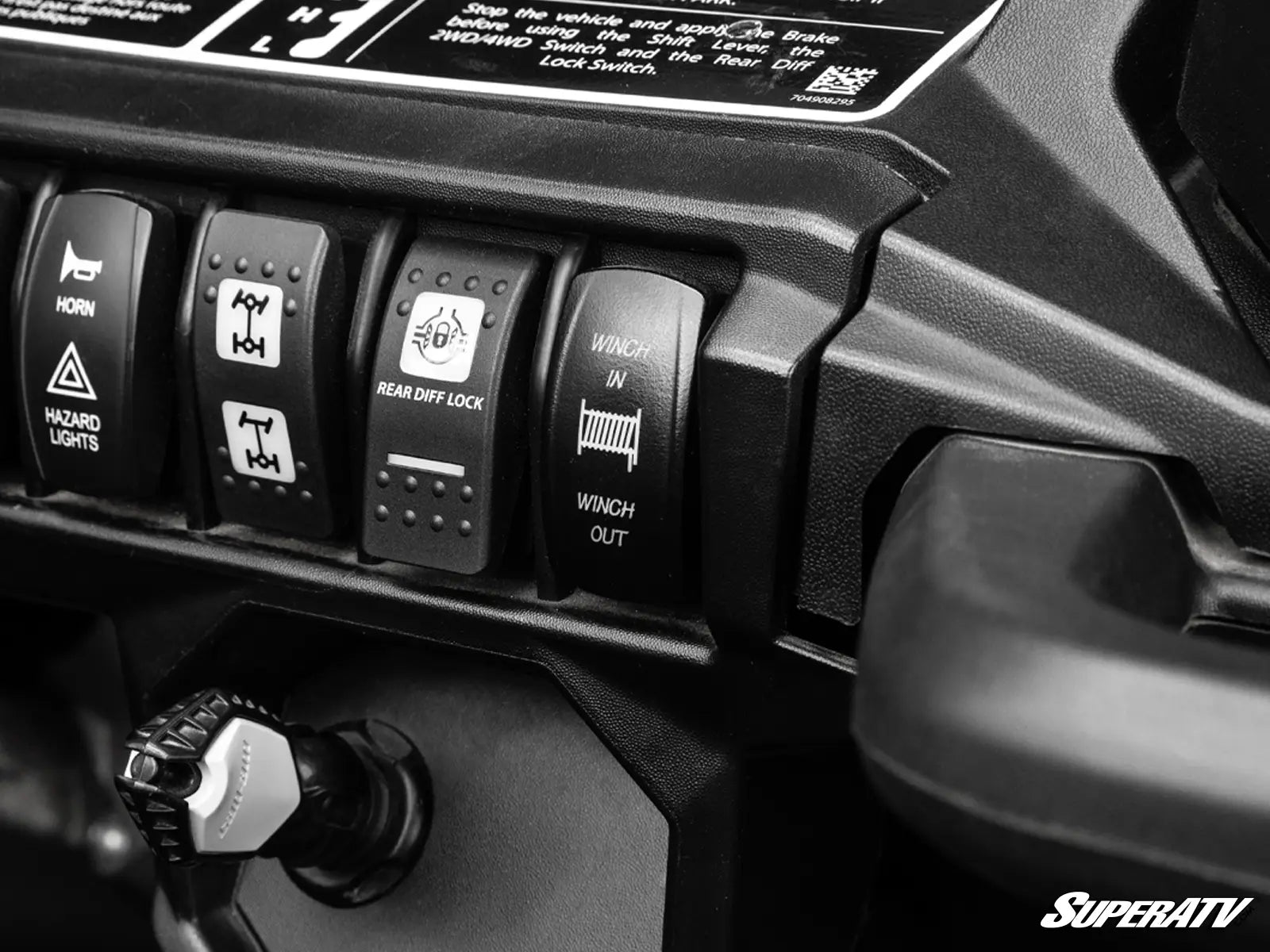 Close-up of vehicle control switches with SuperATV branding.