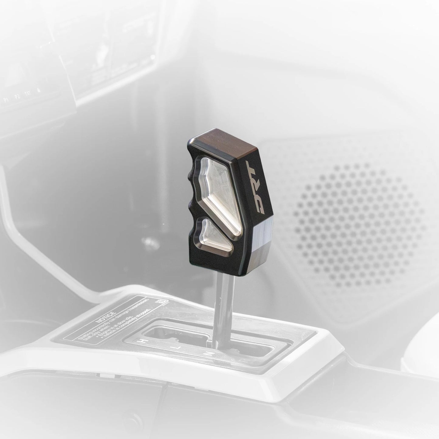 Close-up of a car gear shift lever with a brand logo on a white background