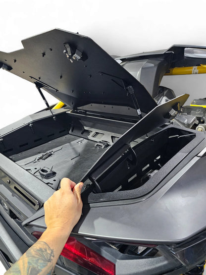 Person opening the trunk of a car with a black protective cover.