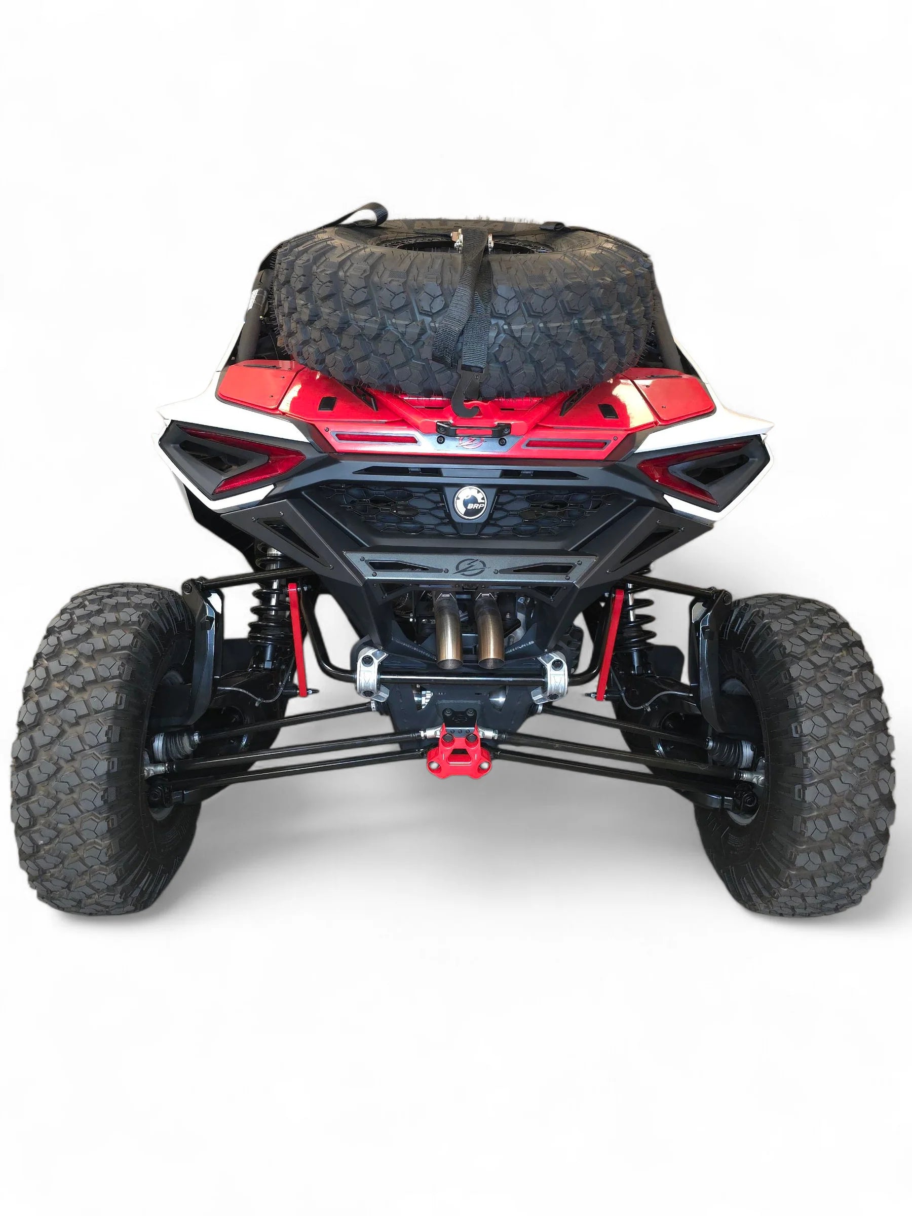 Back view of a red and black off-road vehicle with large tires on a white background
