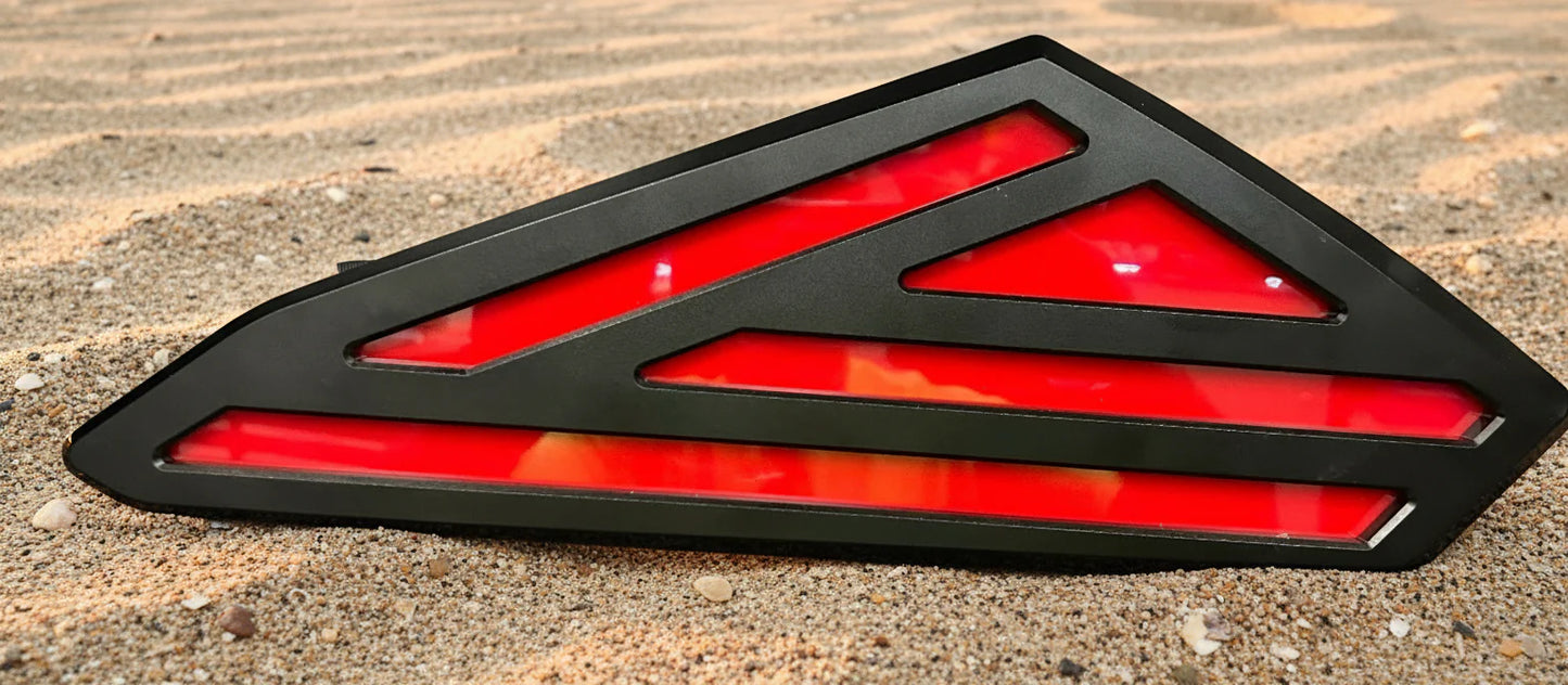 Red and black triangular vehicle light on a textured surface