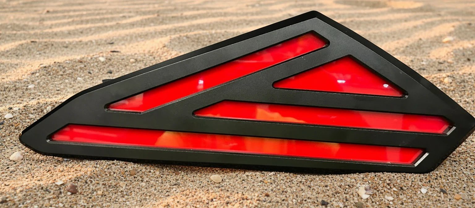 Red and black triangular vehicle light on a textured surface