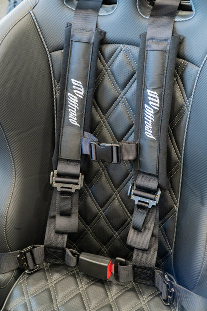 Gray car seat with a detailed harness system on a gray car interior.