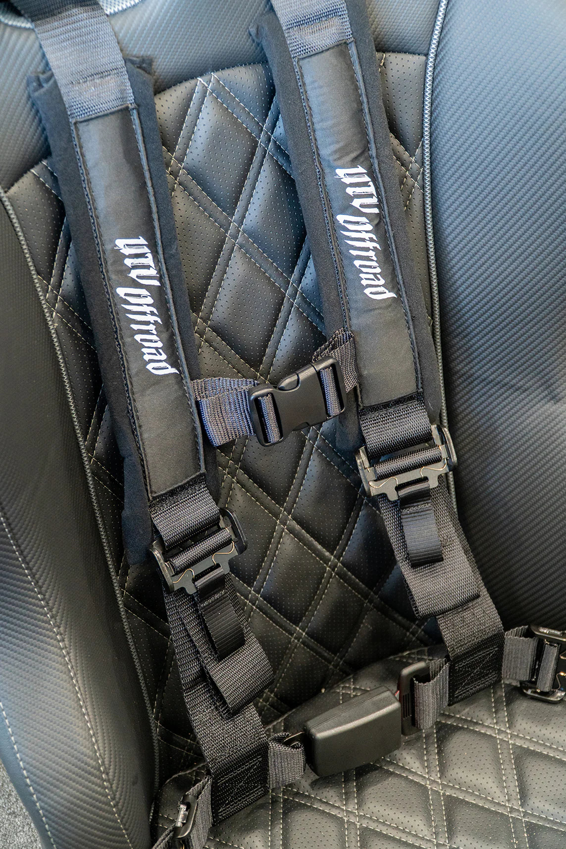 Gray harness seat belt system on a car seat with 'UW Offroad' branding.