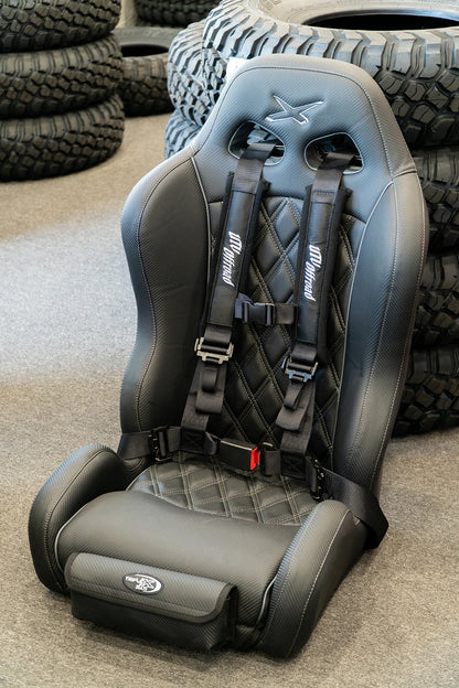 Gray car seat with harnesses in front of stacked tires