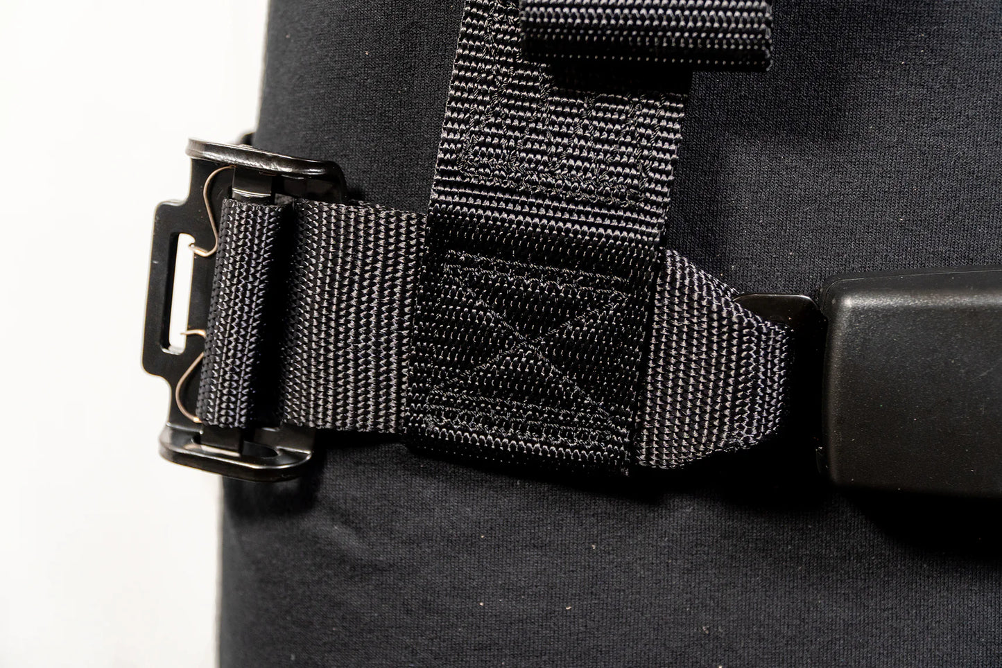 Close-up of a black bag with a buckle and strap on a white background