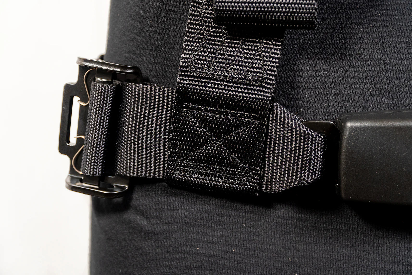 Close-up of a black bag with a buckle and strap on a white background