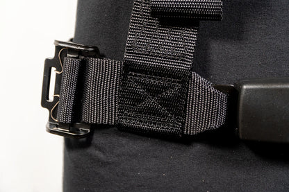 Close-up of a black bag with a buckle and strap on a white background