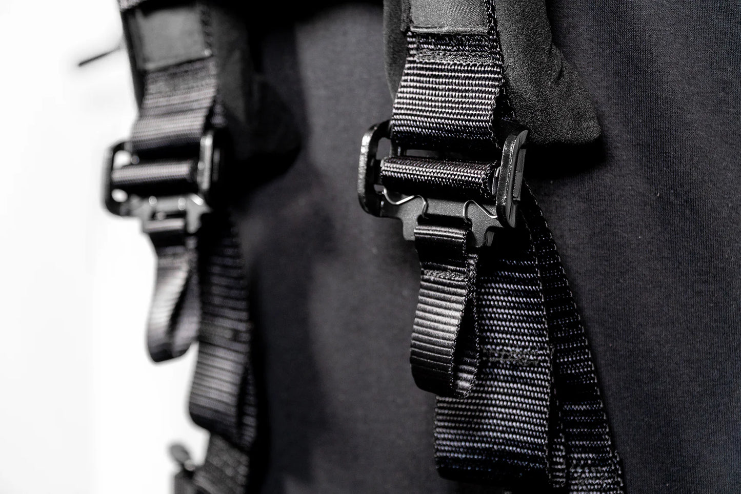Close-up of black straps with metal buckles on a dark background