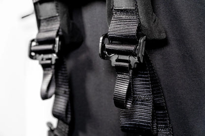 Close-up of black straps with metal buckles on a dark background