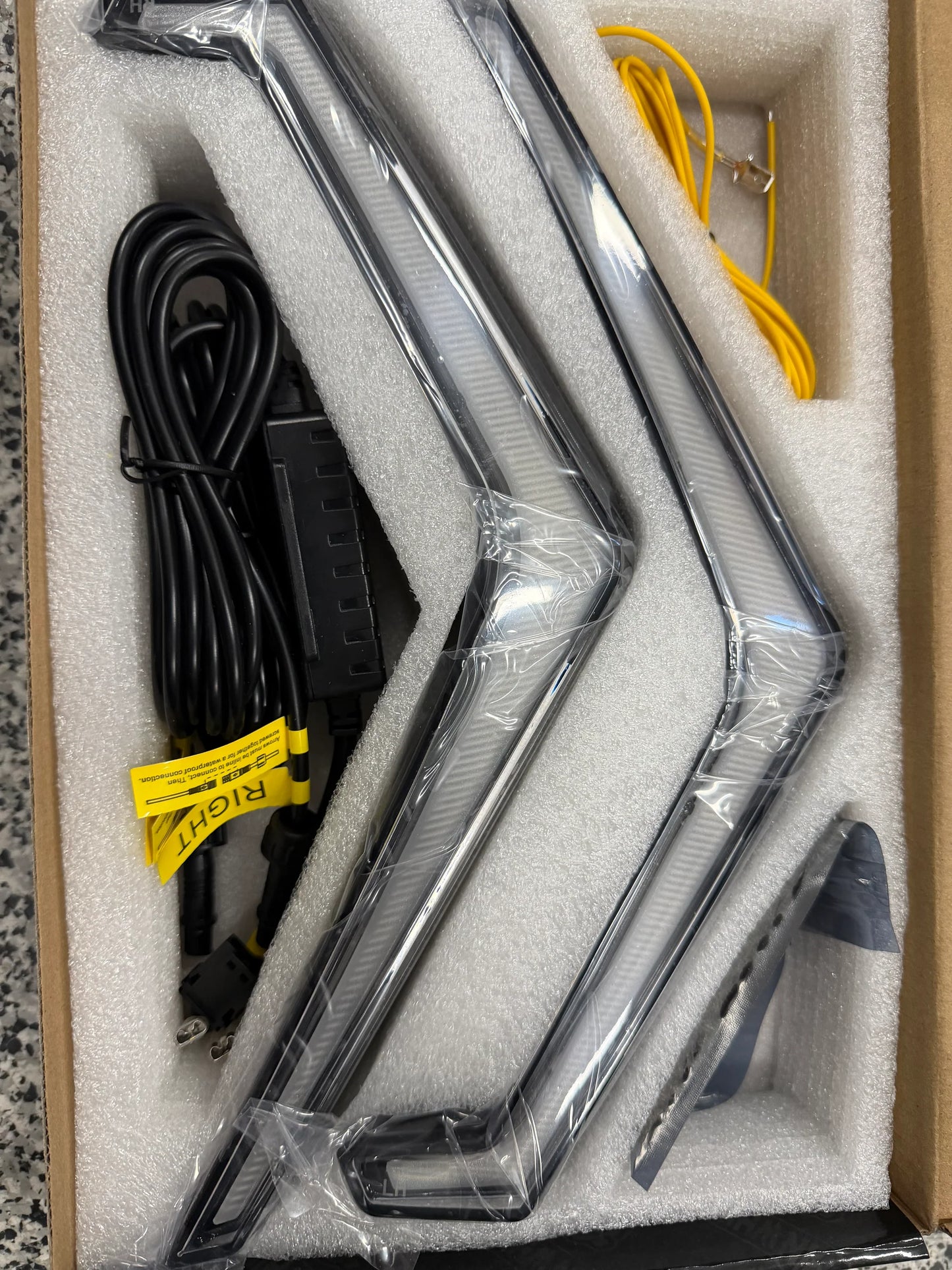 Two metal bars with wiring in a cardboard box